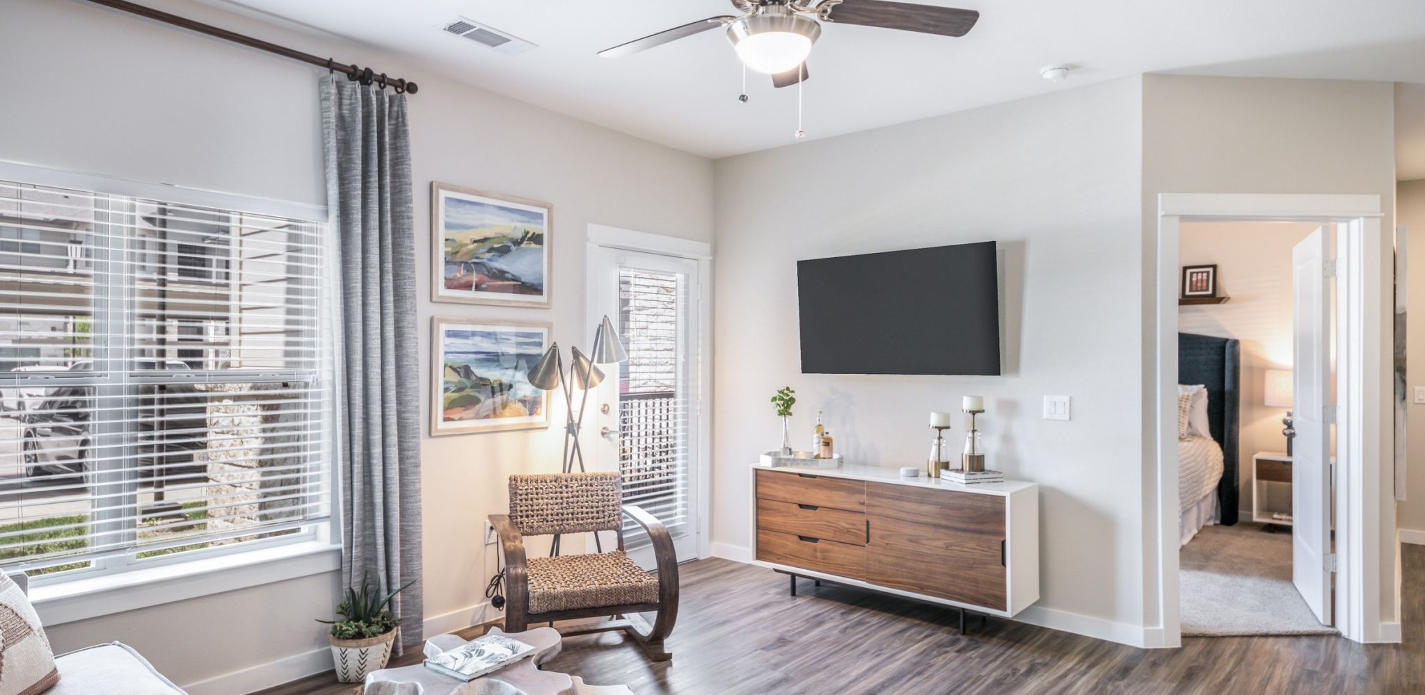 Hawthorne at Blanco Riverwalk apartment living room with large patio doors, furnished with a couch, coffee table, and chair