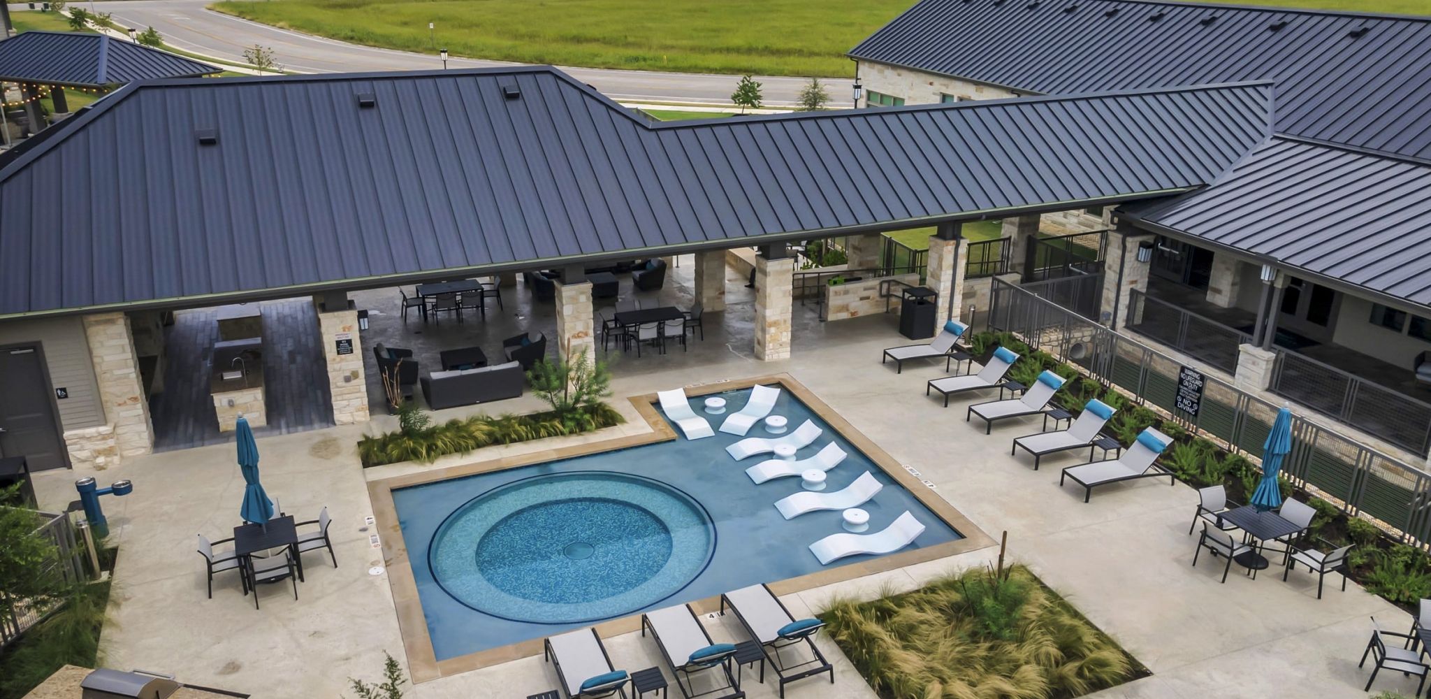 Hawthorne at Blanco Riverwalk aerial view of apartment community pool and surrounding landscape