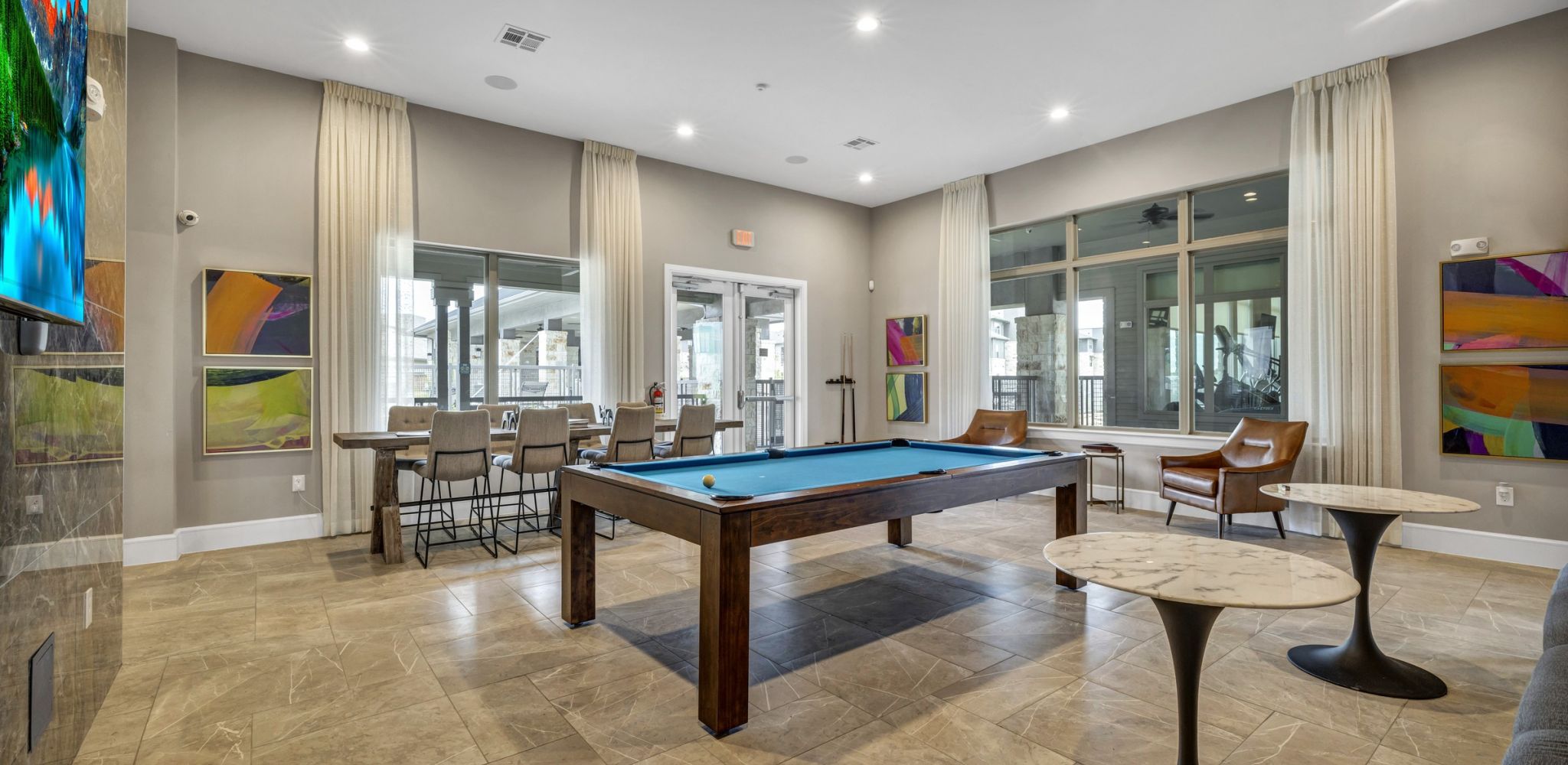 Hawthorne at Blanco Riverwalk amenity lounge area with pool table and entertainment space with tables and chairs